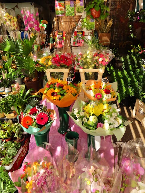 A display of freshly arranged flower bouquets at Harringay Florist, including a vibrant bouquet of pink and red roses, a cheerful arrangement of yellow and orange sunflowers, and a mixed selection of 